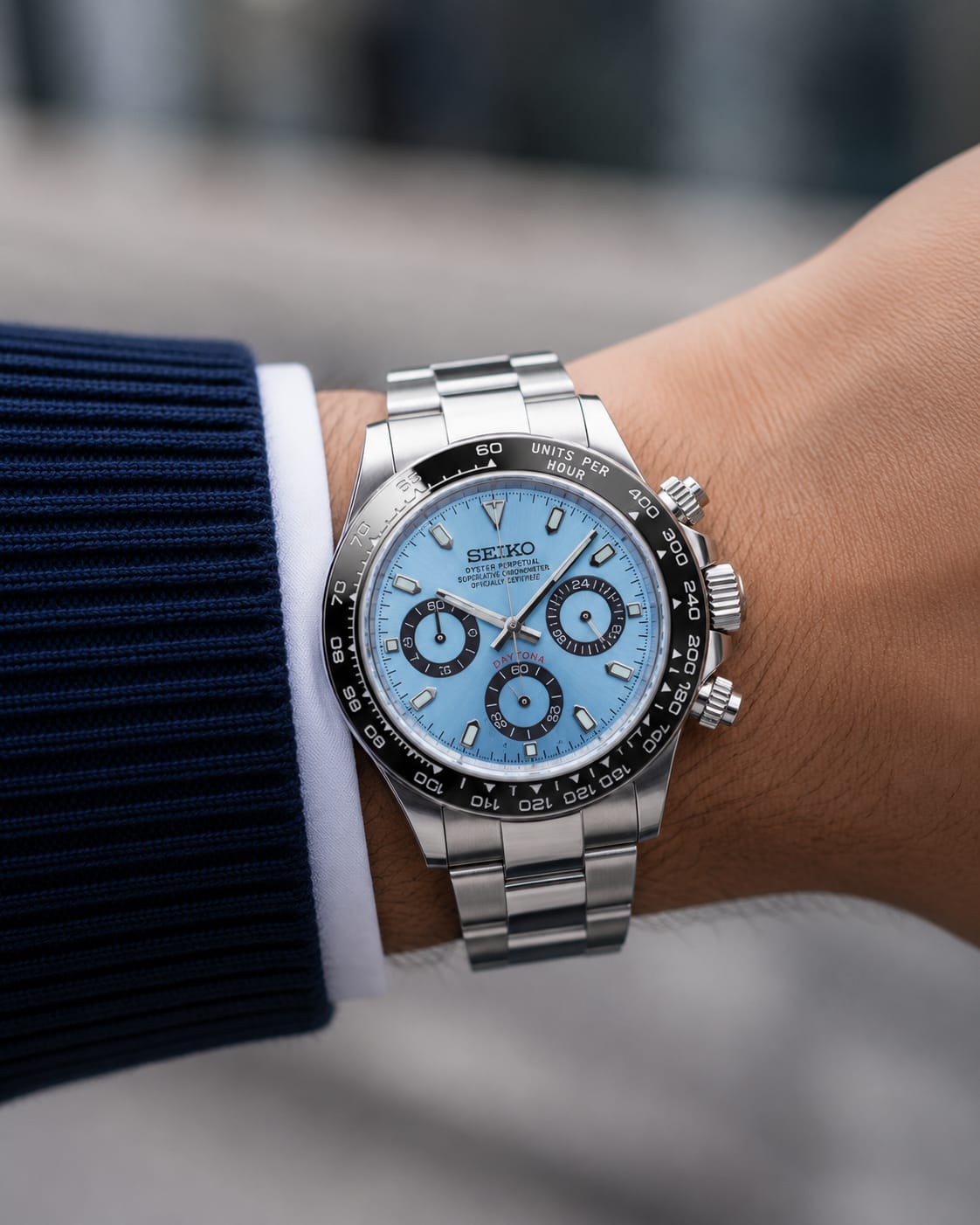 Daytona (Ice Blue Black Bezel) Seiko VK63 meca-quartz chronograph mod watch. A light blue dial watch with a black bezel and metal link bracelet is shown in a wrist shot.