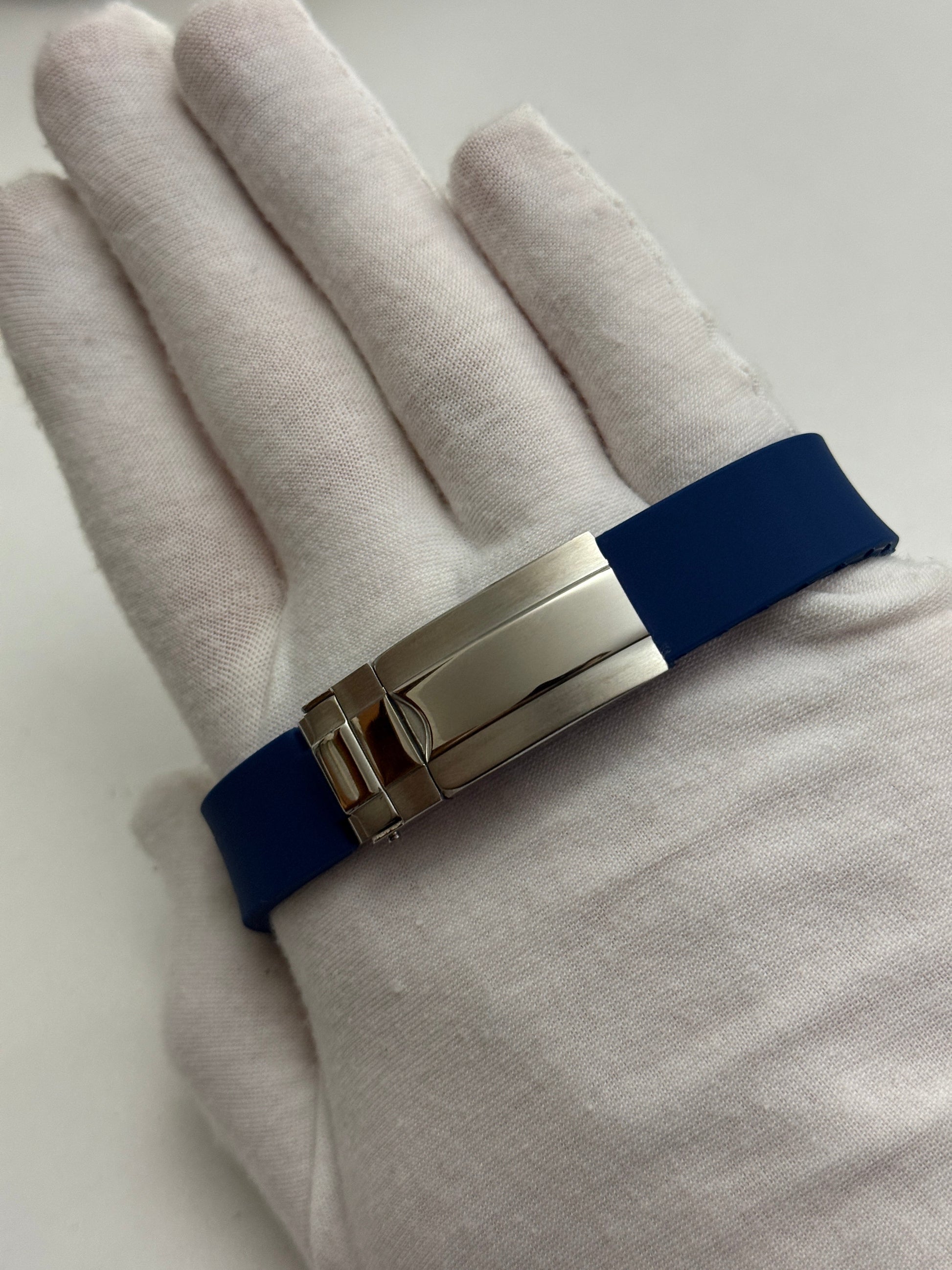 Speedmaster (Blue) Seiko VK63 meca-quartz chronograph mod watch. A detail shot showing the underside of a blue rubber watch strap with a silver metal deployment clasp.