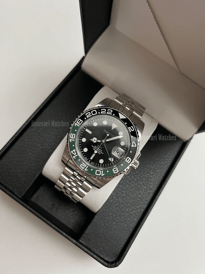 GMT (Sprite) Seiko NH34 GMT automatic mod watch. A full watch with a black dial and a black bezel on a jubilee bracelet inside a watch box.