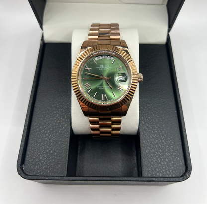 Day-Date (Rose Gold, Green) Japanese automatic mod watch. A full watch shot shows the rose gold watch with a green dial resting on a white pillow inside a box.