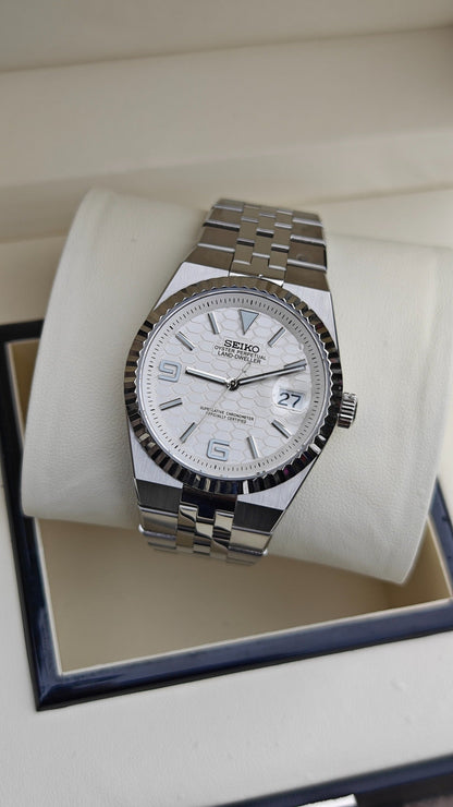 Land-Dweller Seiko NH35 automatic mod watch. A white dial watch with a silver fluted bezel and metal link bracelet inside a white display box.