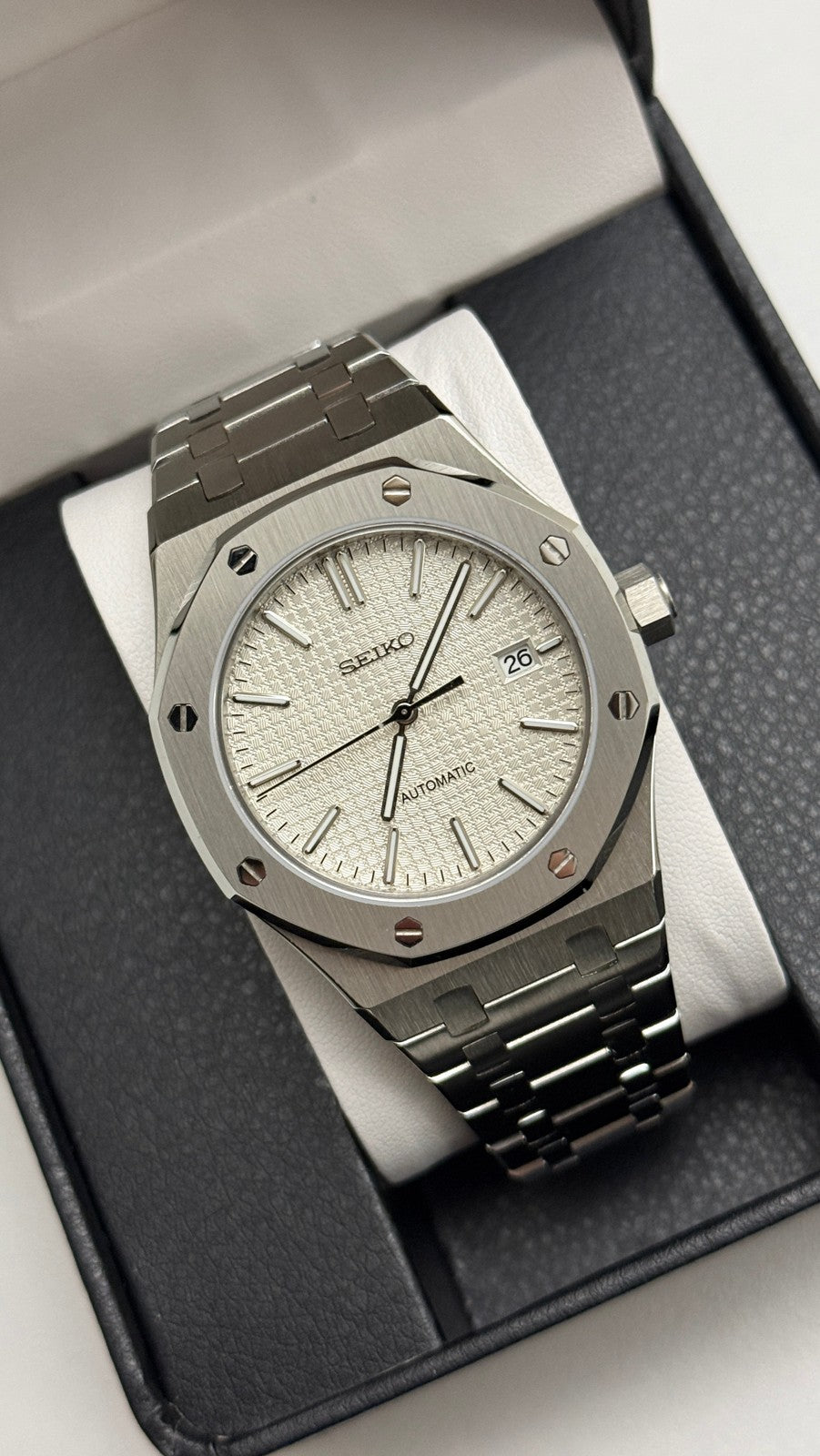 Royal Oak (White) Seiko NH35 automatic mod watch. A silver dial watch with a silver bezel and integrated metal bracelet shown in a full angled shot.