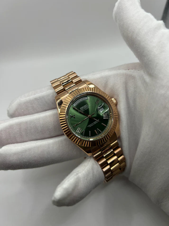 Day-Date (Rose Gold, Green) Japanese automatic mod watch. A wrist shot shows a gloved hand holding the rose gold watch with a green dial and metal link bracelet.
