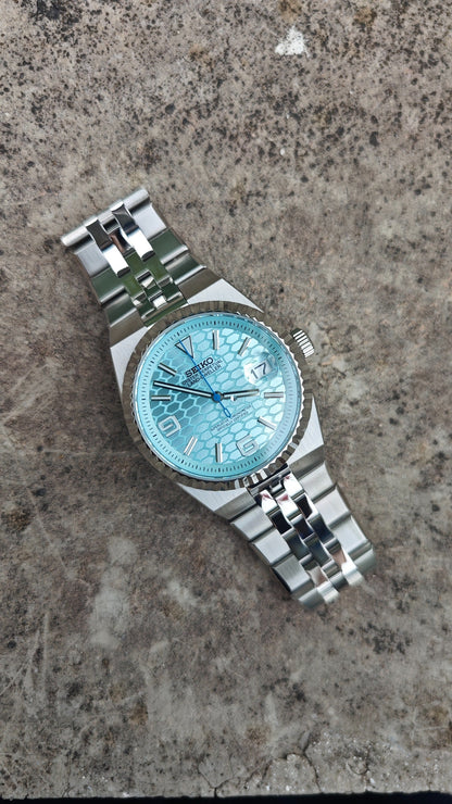Land-Dweller (Tiffany) Seiko NH35 automatic mod watch. A light blue honeycomb dial watch with a silver fluted bezel and jubilee bracelet in a full view.