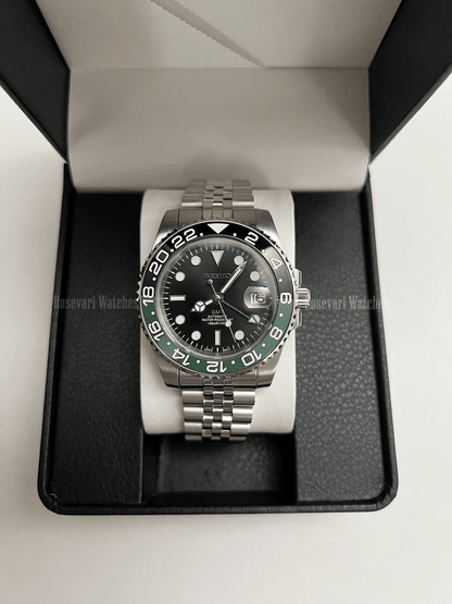 GMT (Sprite) Seiko NH34 GMT automatic mod watch. A full watch with a black dial and a black bezel on a jubilee bracelet inside a watch box.
