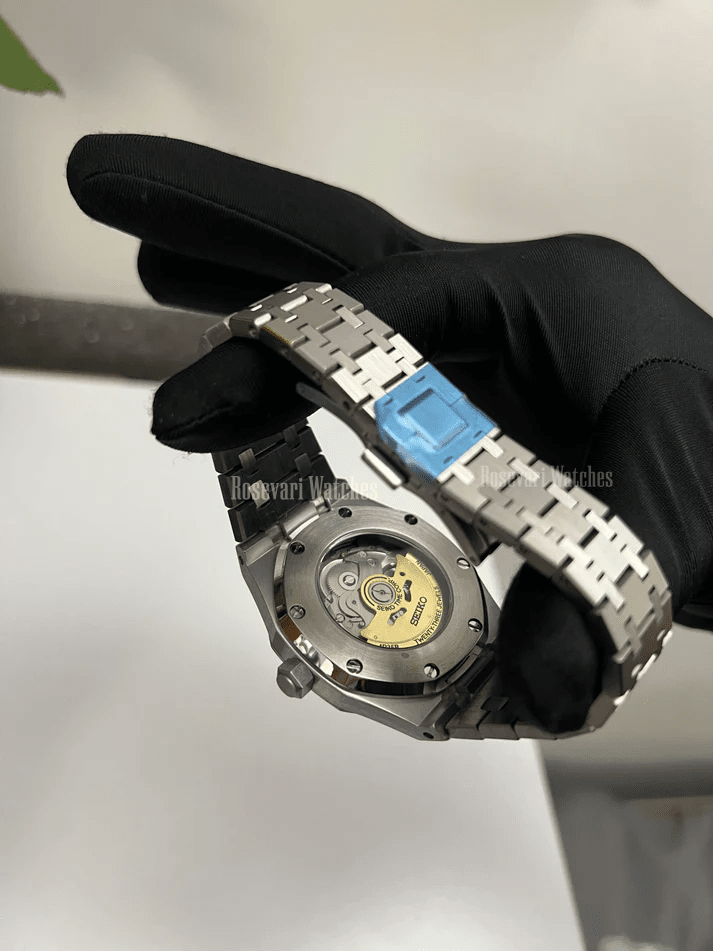 Royal Oak (Blue) Seiko NH35 automatic mod watch. A caseback detail shot showing the mechanical movement with a gold rotor and a metal link bracelet.