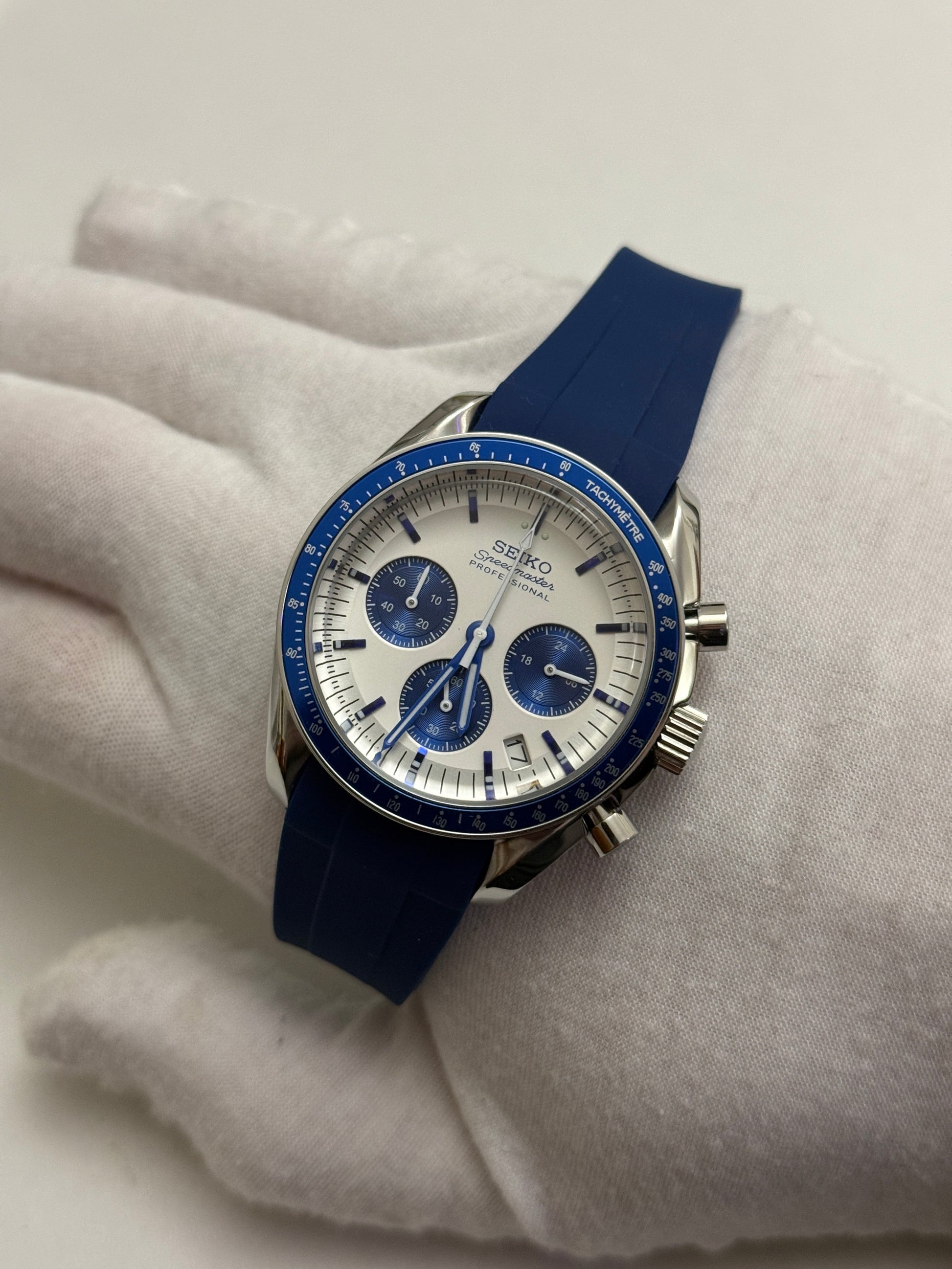 Speedmaster (Blue) Seiko VK63 meca-quartz chronograph mod watch. A full watch shot showing a white dial with blue sub dials and a blue bezel on a blue rubber strap.