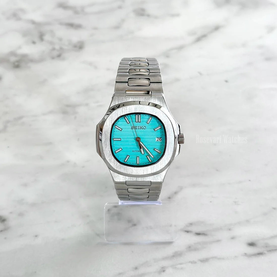 Nautilus (Tiffany Blue) Seiko NH35 automatic mod watch. A full watch shot on a marble surface displays a turquoise dial with a silver bezel and metal link bracelet.