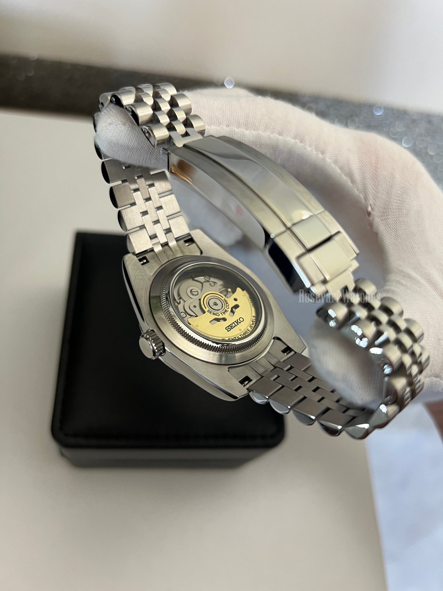 GMT (Batman) Seiko NH34 GMT automatic mod watch. A caseback detail shot showing the internal mechanical movement and a silver jubilee bracelet.