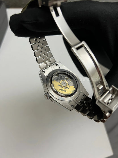 GMT (Sprite) Seiko NH34 GMT automatic mod watch. A caseback detail showing the mechanical movement of the watch with a gold rotor.