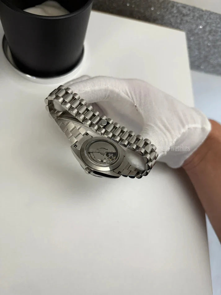 Day-Date (Blue Roman) Japanese automatic mod watch. A caseback detail showing the mechanical movement through a clear window on a silver metal bracelet.