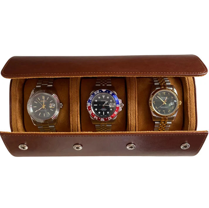3 Piece - Watch Travel Case (Brown). An open brown leather watch roll displays three watches with metal bracelets in a studio shot.