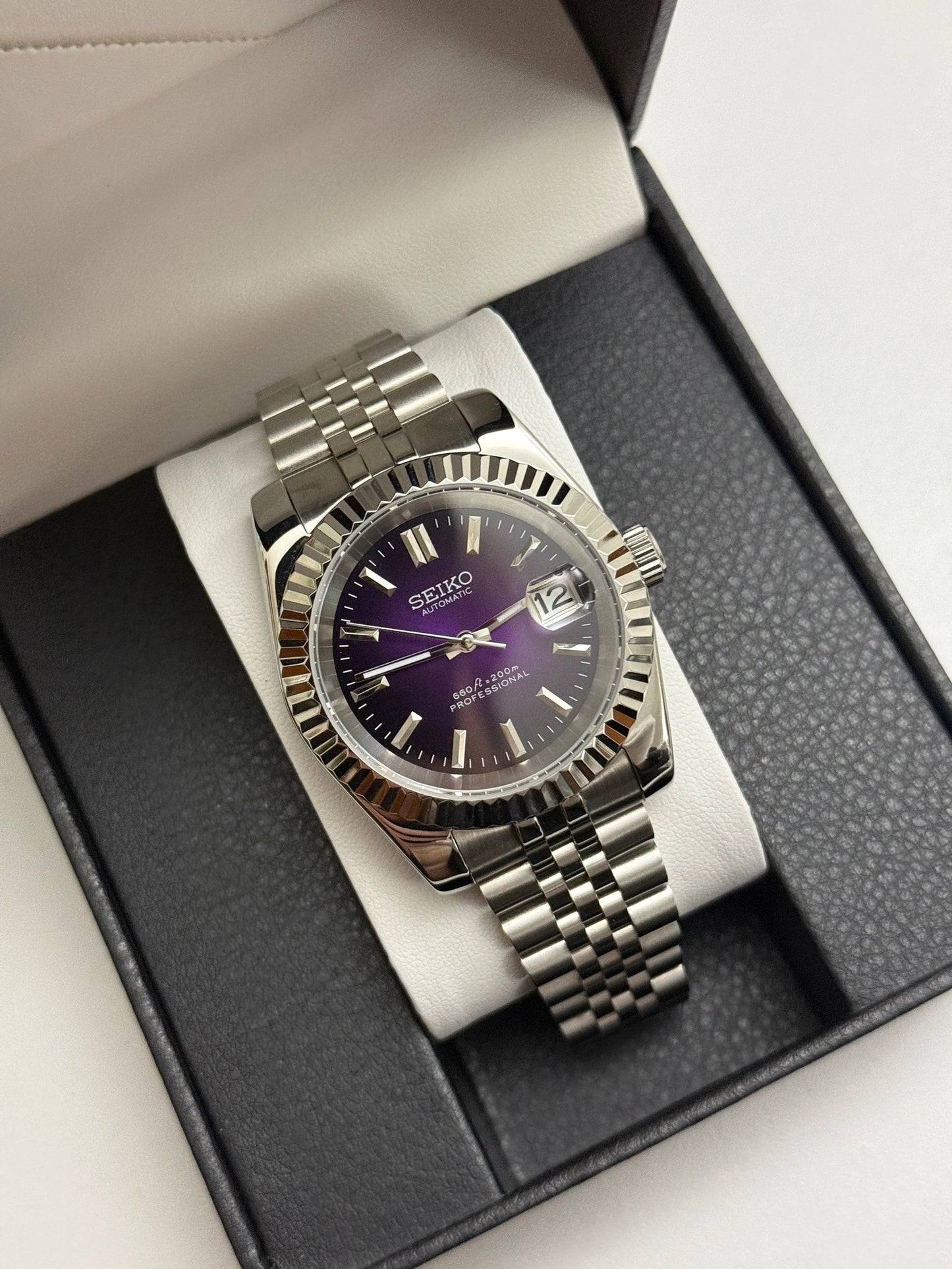 Datejust (Purple) Seiko NH35 automatic mod watch. A full watch shot inside a box featuring a purple dial with a silver fluted bezel and silver bracelet.