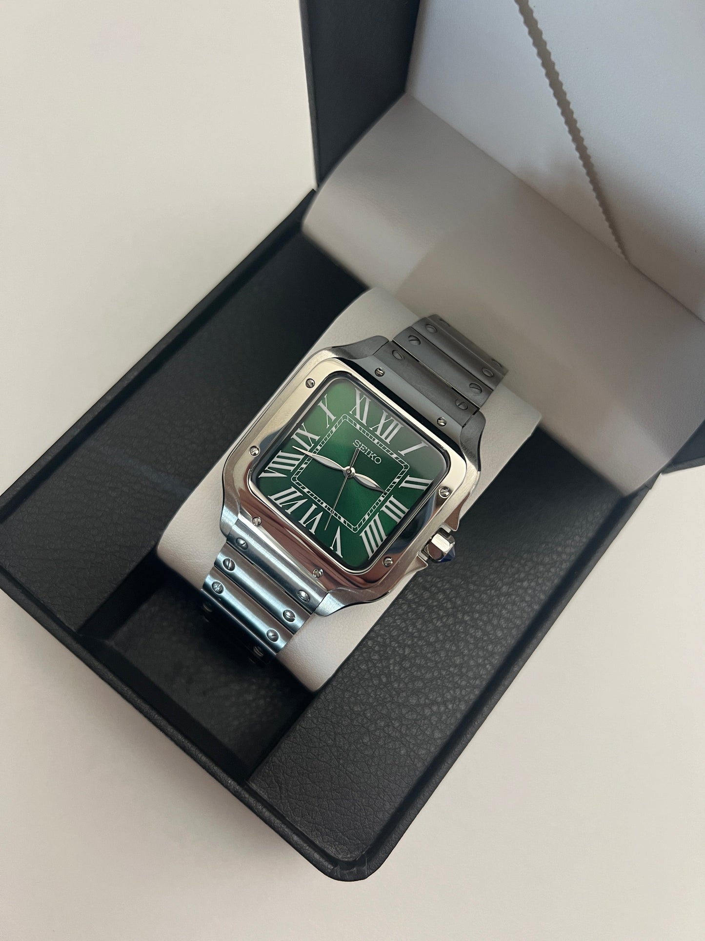 Santos (Emerald Green) Seiko NH35 automatic mod watch. A full watch shot inside a box showing a green dial and silver bezel with a metal bracelet.